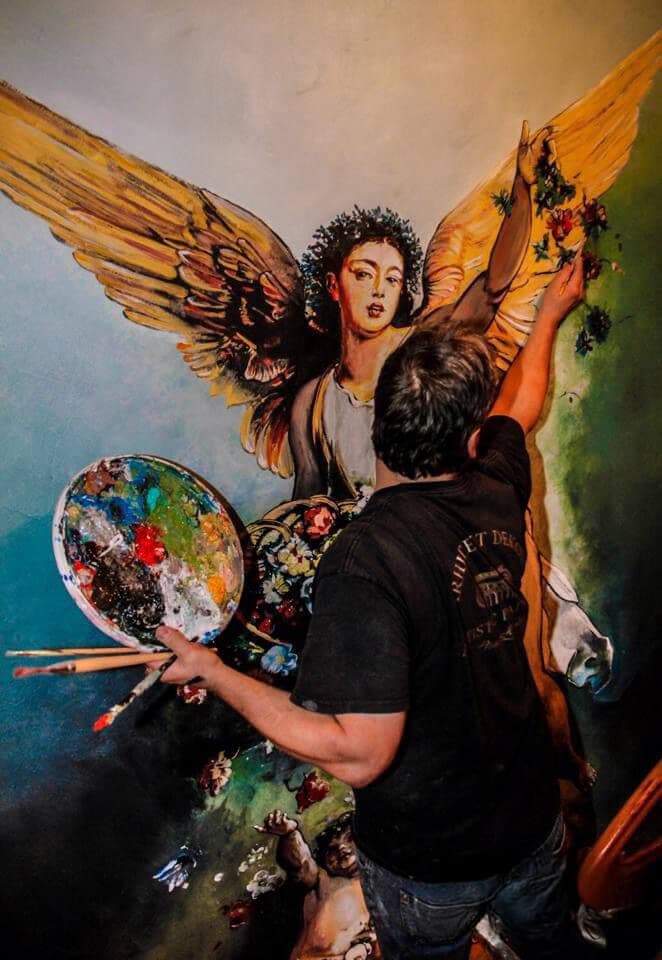 Toni Hamler painting a stunning angel mural, demonstrating his expertise in large-scale decorative artworks and artistic wall finishes.