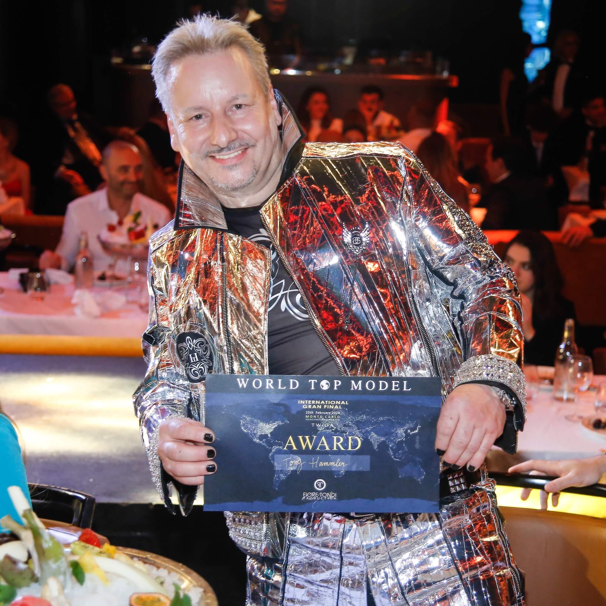 Toni Hamler receiving the prestigious World Top Model International award for his exclusive wallpaper-inspired fashion and artistic creations.