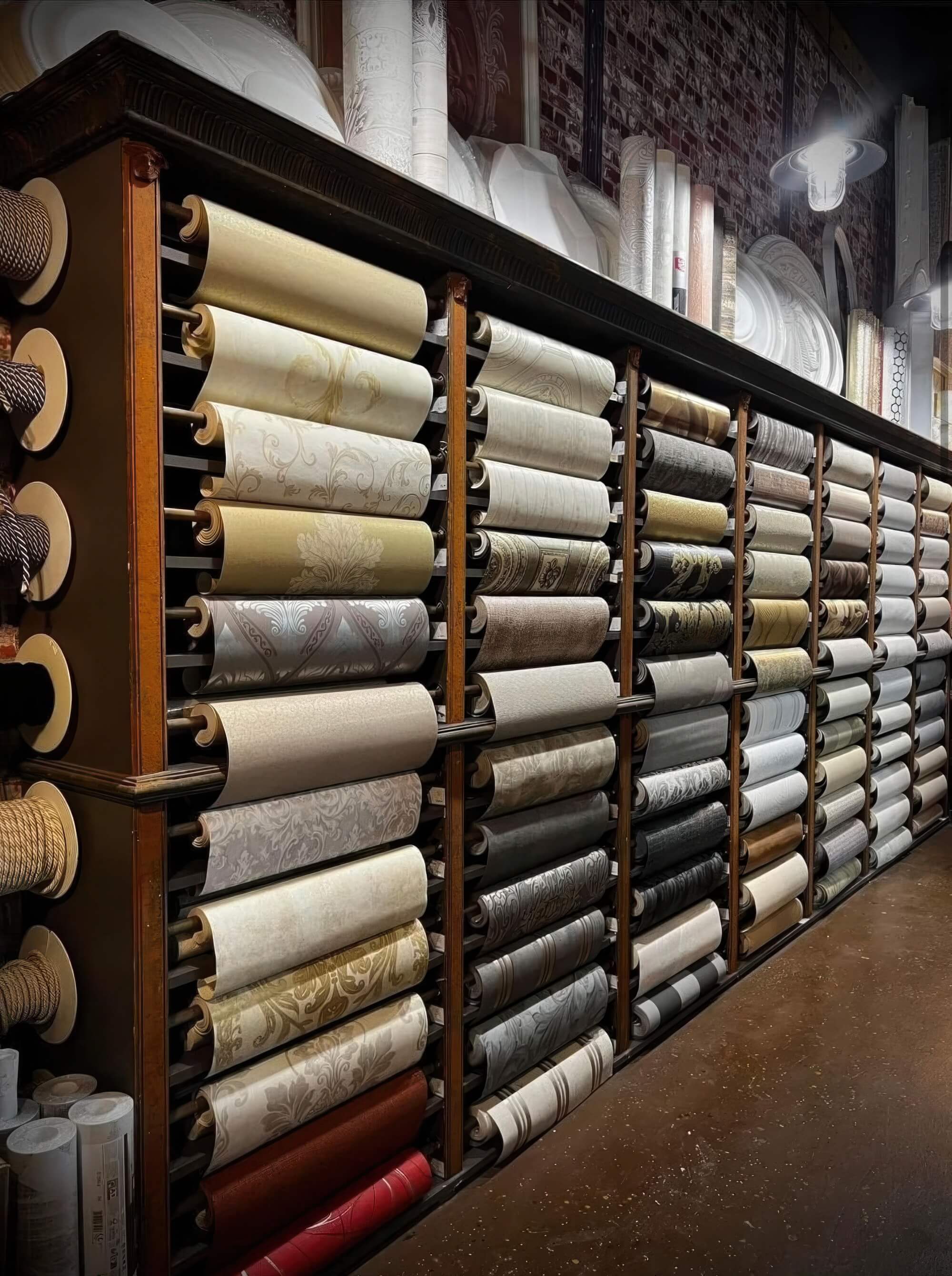 A luxurious display of high-end wallpaper rolls at Toni Hamler’s wallpaper store, showcasing classic and modern designs.